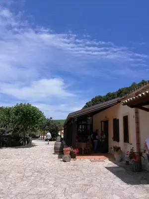 a building with people sitting outside of it at Agriturismo Tenute Pispisa Segesta in Calatafimi