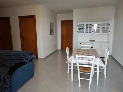 a bedroom with a table and chairs and a bed at Bellavista Apartments in Scopello