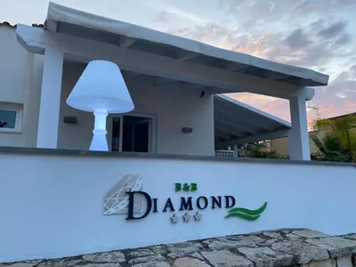 a sign in front of a house with a lamp at B&b Diamond in San Vito lo Capo