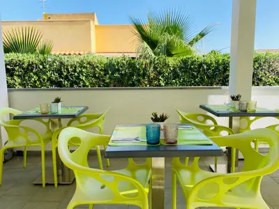 a row of tables and chairs on a patio at B&b Diamond in San Vito lo Capo