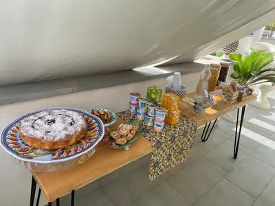 a table with a cake and other food on it at B&b Diamond in San Vito lo Capo