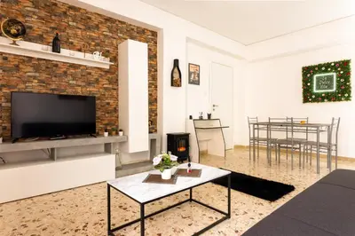 a living room with a television and a brick wall at Casa Vacanze La Dolce Vita in Terrasini