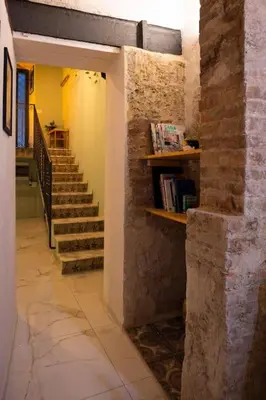 a hallway with stairs and a book shelf with books at Normanni Underground in Palermo