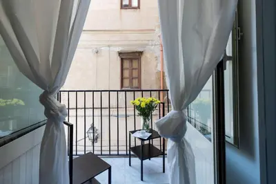 a window with a vase of flowers on a balcony at Olivella 11 in Palermo