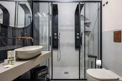 a bathroom with a shower and a sink and a toilet at D'ossuna66 Suite & Spa in Palermo