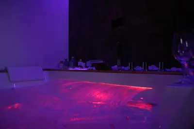 a dark room with a table with a wine glass at Spera Luxury Palermo & SPA in Palermo