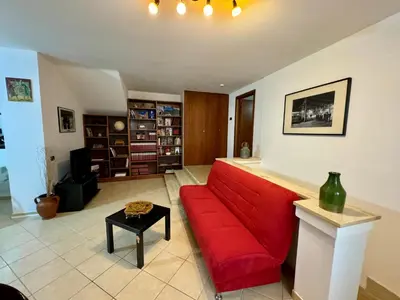 a living room with a red couch and a table at Civico 22 Casa Vacanza in Torretta