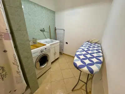 a laundry room with a washing machine and a stool at Civico 22 Casa Vacanza in Torretta