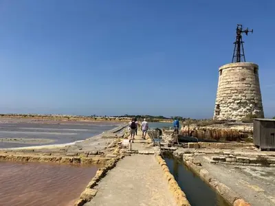two people walking along a pathway near a lighthouse at Civico 22 Casa Vacanza in Torretta