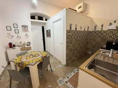 a small kitchen with a table and a sink at Tra i vicoli di Ballarò in Palermo