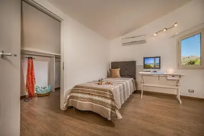 a bedroom with a bed and a desk in it at Borgo Aranci - Villa Nicales in Castellammare del Golfo