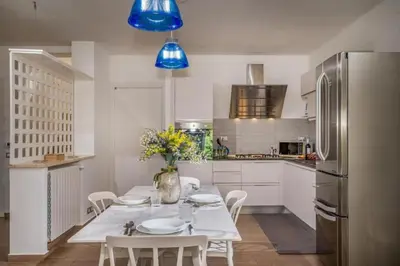 a kitchen with a table with chairs and a refrigerator at Borgo Aranci - Villa Nicales in Castellammare del Golfo