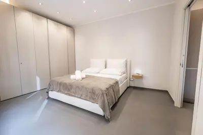 a bedroom with a white bed with two towels on it at Teatro Apartments Villafranca in Palermo
