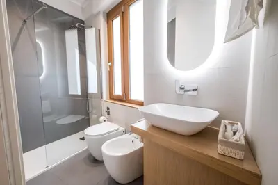 a bathroom with a sink and a toilet and a shower at Teatro Apartments Villafranca in Palermo