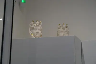two statues of heads with crowns on top of a cabinet at 27 Apartaments Palermo in Palermo