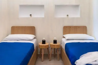 two beds in a room with two candles on tables at Villa Faraglioni Cala Bianca in Castellammare del Golfo