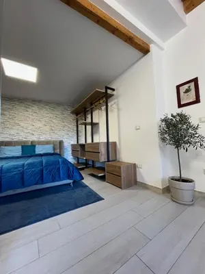 a bedroom with a blue bed and a brick wall at La Terrazza di Nela in Bagheria