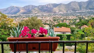 a pot of flowers sitting on a balcony with a view at Casale di Sicilia in Monreale