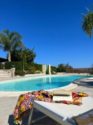 a blanket laying on a table next to a swimming pool at Villa Ninetta in Scopello