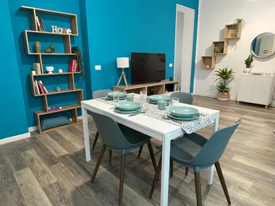 a dining room with a white table and blue chairs at Quintino Sella 41 Apartment in Palermo