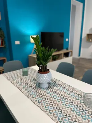 a table with a plant in a vase on it at Quintino Sella 41 Apartment in Palermo