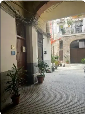 an empty courtyard with potted plants in front of a building at La Casetta al Cassaro in Palermo