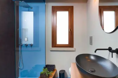 a bathroom with a sink and a glass shower at Villa Scogliera Cala Bianca in Castellammare del Golfo
