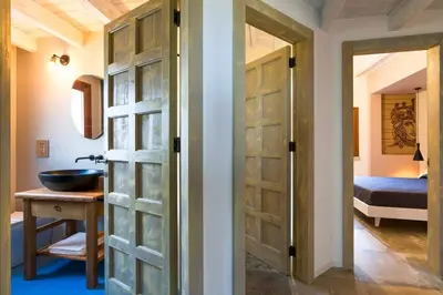 a bathroom with a door leading to a bedroom at Villa Scogliera Cala Bianca in Castellammare del Golfo