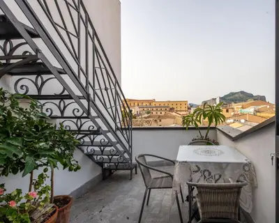 a balcony with a table and chairs and a staircase at Alloro House with Terrace by Wonderful Italy in Palermo
