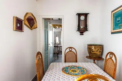 a dining room with a table and a clock on the wall at Alloro House with Terrace by Wonderful Italy in Palermo