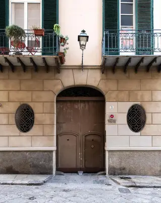 a building with a brown door and two windows at Alloro House with Terrace by Wonderful Italy in Palermo