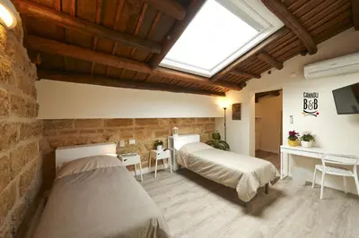a bedroom with two beds and a skylight at B&B Cannoli in Palermo