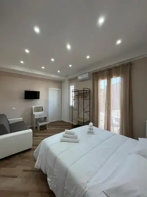 a bedroom with a large white bed and a couch at Casa Miriam 281 in Palermo