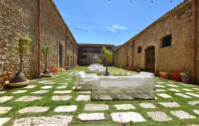 a row of white tables in a courtyard at 1 Bedroom Stunning Home In Partinico in Partinico