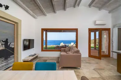 a living room with a couch and a view of the ocean at Villa Zingaro Cala Bianca in Castellammare del Golfo