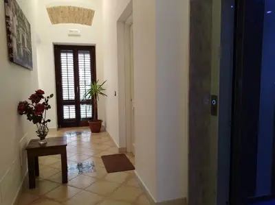 a hallway with a room with a door and a table at Patania Royal Apartment in Palermo