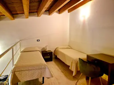 a bedroom with two beds and a desk and a desk at Patania Royal Apartment in Palermo