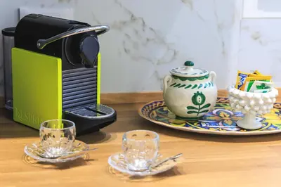 a toaster sitting next to a plate with glasses on a table at Merlo5 in Palermo