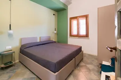 a bedroom with a bed in a room with green walls at Villa Scopello Cala Bianca in Castellammare del Golfo