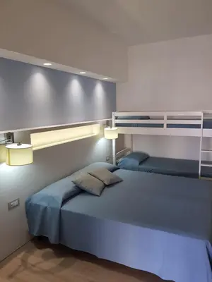 a bedroom with a blue bed with two pillows at Hotel Perla Gaia in San Vito lo Capo