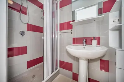 a bathroom with a white sink and red and white stripes at Trinacrys - Casa Vacanze in Alcamo