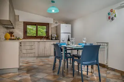 a kitchen with a table with chairs and a refrigerator at Trinacrys - Casa Vacanze in Alcamo