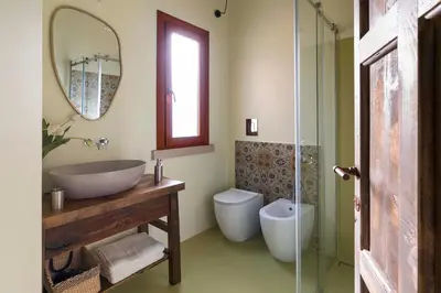 a bathroom with a sink and a toilet and a mirror at Villa Ancora Cala Bianca in Castellammare del Golfo