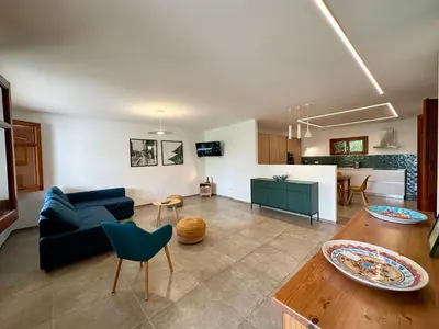 a living room with a blue couch and a table at Villa Sao Scopello Punta Pispisa in Scopello