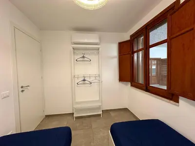a room with a closet with hangers and a window at Villa Sao Scopello Punta Pispisa in Scopello
