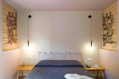 a bedroom with a bed with two tables and two lights at Villa Mori Cala Bianca in Castellammare del Golfo