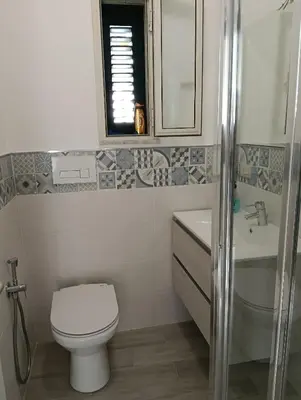 a bathroom with a toilet and a sink and a mirror at Casa Nicuzza alla Zisa in Palermo