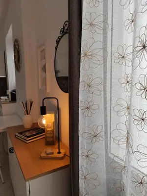 a desk with a lamp and a curtain with flowers at Casa Nicuzza alla Zisa in Palermo