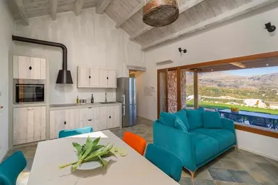 a kitchen with a table and some blue chairs at Villa Disa Cala Bianca in Castellammare del Golfo