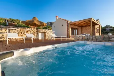 a pool with a patio and a house at Villa Disa Cala Bianca in Castellammare del Golfo